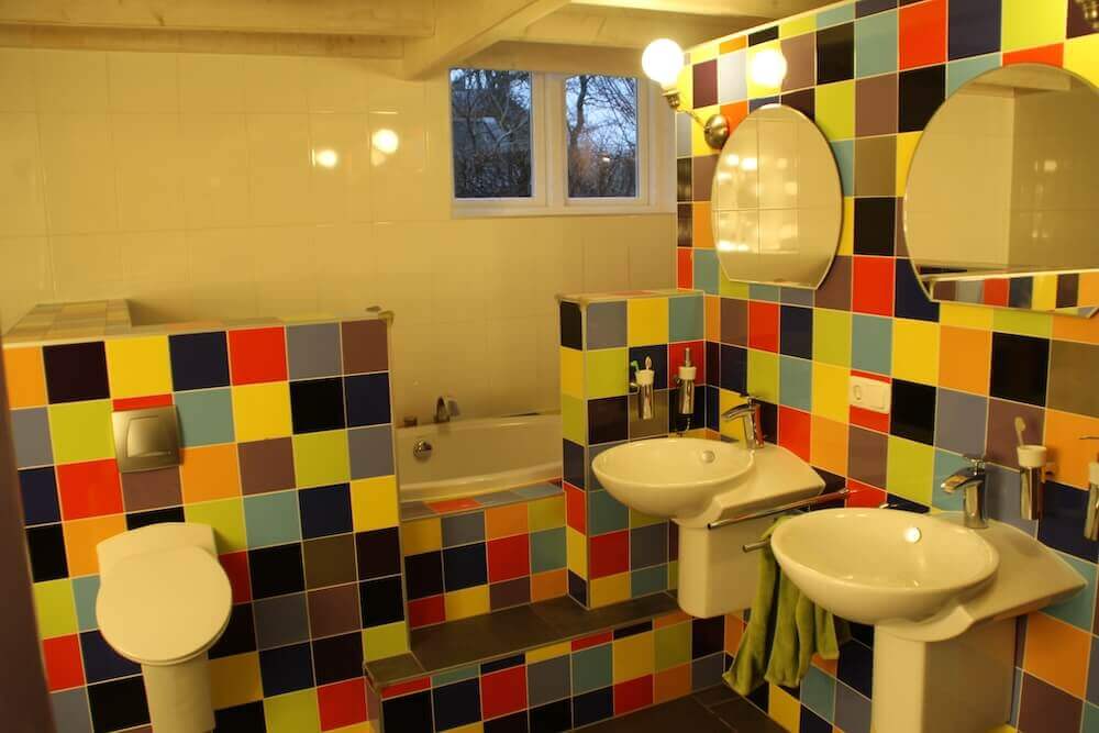 Foto van badkamer met wandtegels in allerlei bonte kleuren